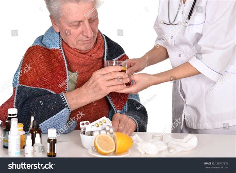 Doctor Treats Sick Elderly Man Over A White Background Stock Photo
