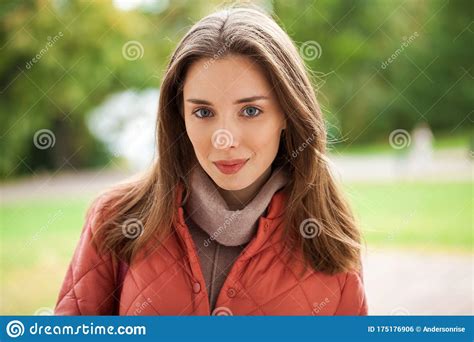 Close Up Portrait Of A Young Beautiful Brunette Girl In Coral Coat