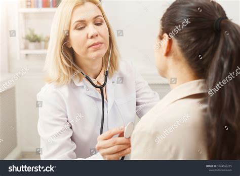 Serious Doctor Stethoscope Checking Patient Heart Stock Photo