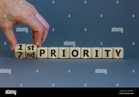 1st Or 2nd Priority Symbol Businessman Turns Wooden Cubes And Changes