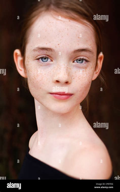 A Close Up On A Young Freckled Girls Face Looking At The Camera Stock