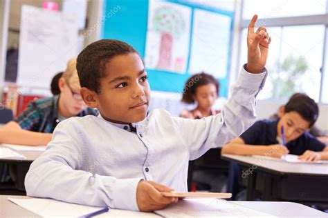 Niño Levantando La Mano En La Clase Escolar Fotografía De Stock