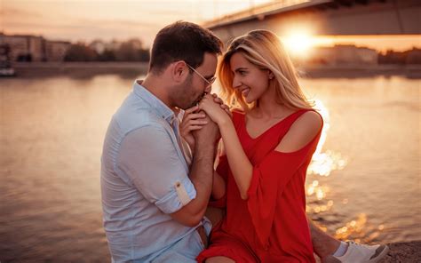 Pretty Couple Sitting By River Adores Kissing Bridge Sunset 