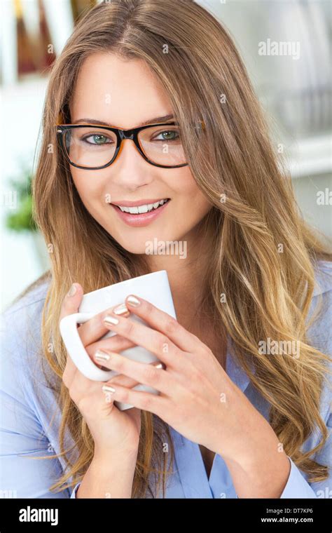 Beautiful Young Blond Woman At Home In Her Kitchen Wearing Geek Glasses