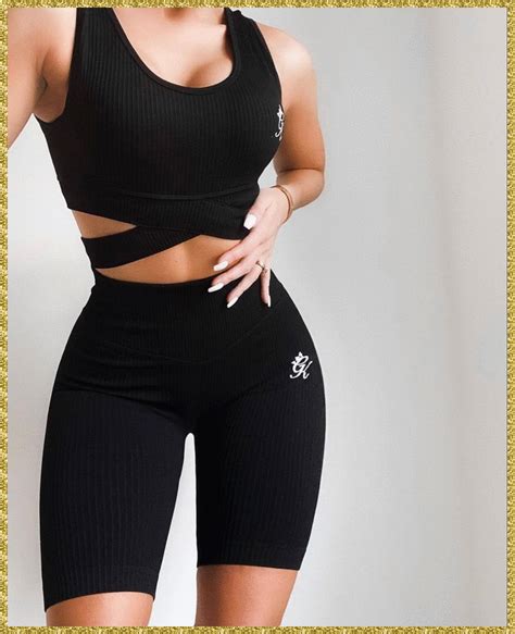 A Woman In Black Sports Bra Top And Shorts With Her Hands On Her Hips