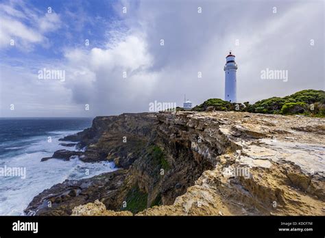 Cape Nelson Lighthouse Standing On A Rugged Cliff Above Ocean Under
