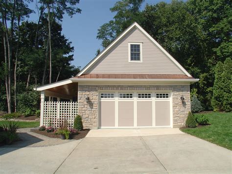 A House With Two Garages In Front Of It And Trees Around The Back Yard