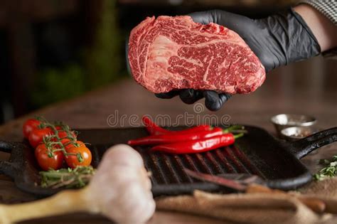 Check spelling or type a new query. A Hand In A Black Glove Holds A Juicy Fresh Rib-eye Steak ...