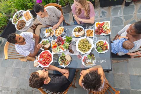 A Group Of Young Adult Friends Dining Al Fresco On A Patio High Res