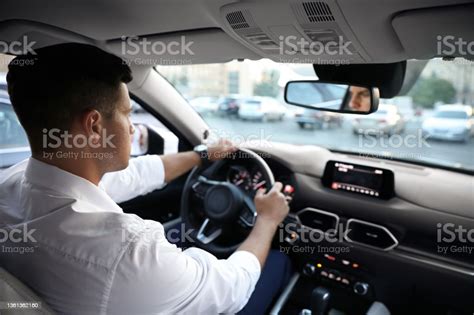 Man Driving His Modern Luxury Car View From Backseat Stock Photo