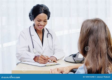 Black Female Doctor Consulting With European Patient About Her Health In Hospital Medical
