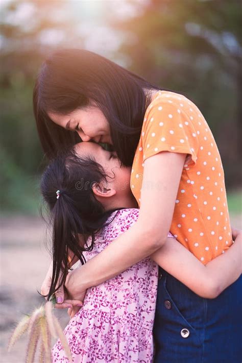 beautiful asian mother hugging her little daughter outdoors nature stock image image of love