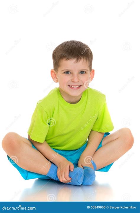 The Child Sits On The Floor With Folded Legs Under Stock Photo Image