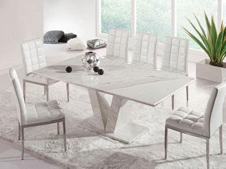 Parnella dining set round, white dining table with blue upholstered chairs set on a gray and white rug. Hera White Grey Marble V Leg Dining Table and 6 Chairs