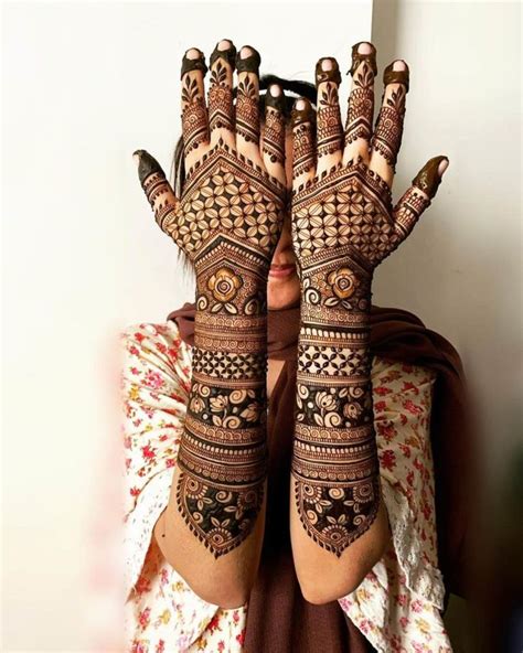 A Woman With Her Hands Covered In Henna