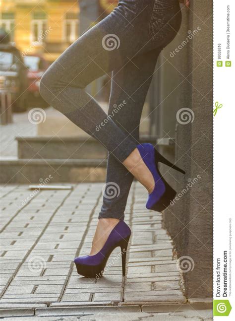 Beautiful Slender Female Legs In Tight Jeans And Blue Velvet High Heeled Shoes Slipped Stock
