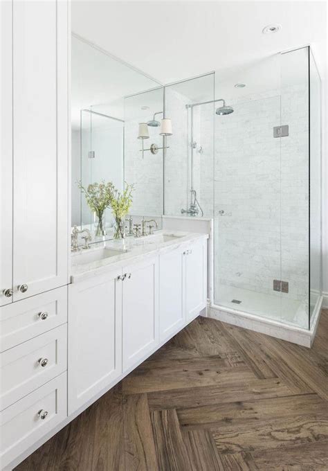 Master Bathroom With Herringbone Wood Floor Marble Shower And Countertops White Cabinets