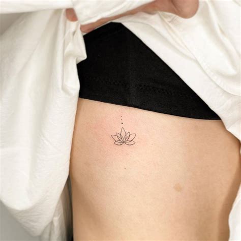 Fine Line Style Lotus Flower Tattoo Done On The Rib