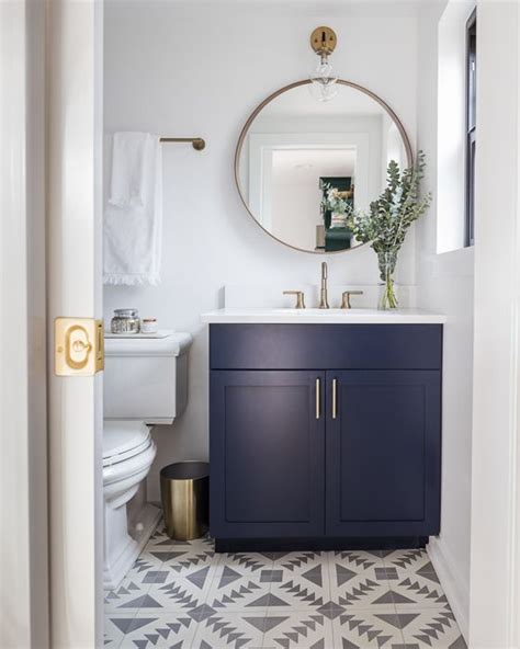 Modern Bathroom With Navy Blue Vanity Gold Accents And Patterned