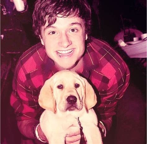 Josh Hutcherson In A Plaid Shirt With His Puppy Smiling