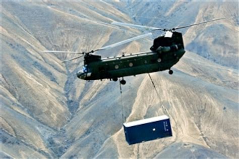 A Us Army Ch 47 Chinook Helicopter Carries A Sling Loaded Shipping