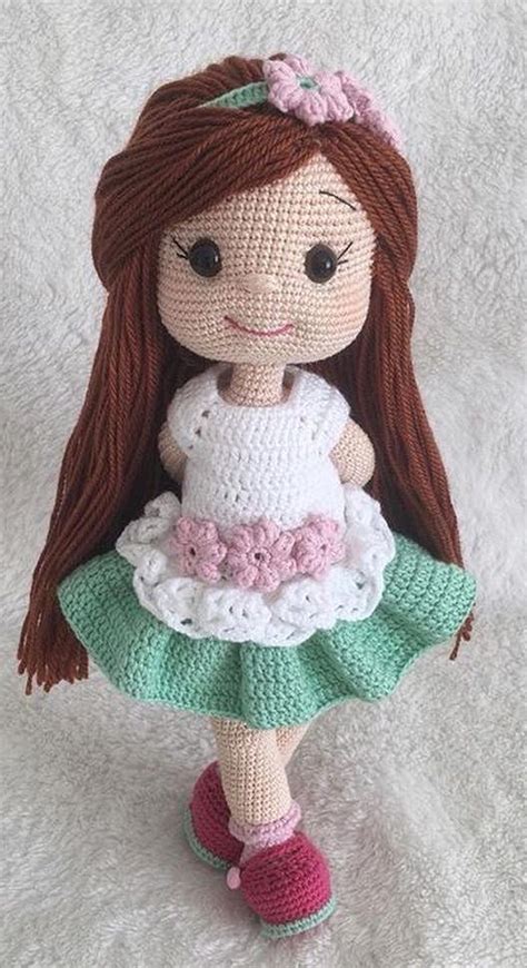 A Crocheted Doll With Brown Hair Wearing A Green Dress And Pink Shoes
