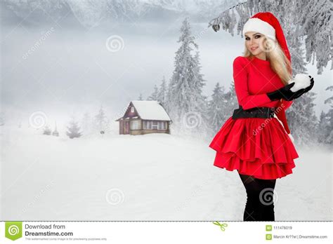 Belle Femme Blonde Sexy Utilisant Une Robe Rouge Et Un Chapeau Du ` S De Santa Dans Les