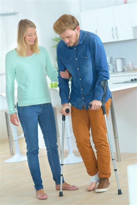 Lady Helping Man On Crutches Stock Photo Image Of Crutches