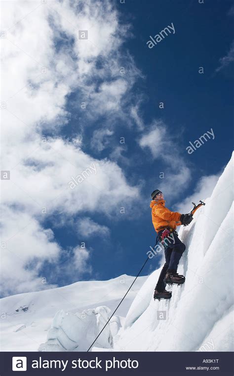 Mountain Climber Going Up Snowy Slope With Axes Stock Photo Alamy