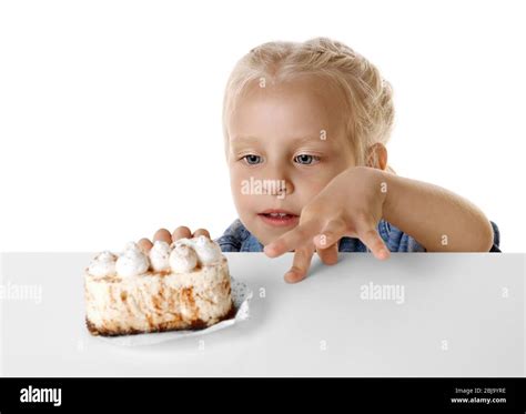 Funny Little Girl Hiding Behind White Table And Looking At Tasty Cake