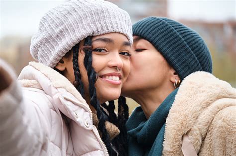 pasangan lesbian dominika yang bahagia mengambil selfie sambil mencium pipi foto stok unduh