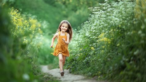 Cute Little Girl Is Running On Path Wearing Yellow Dress