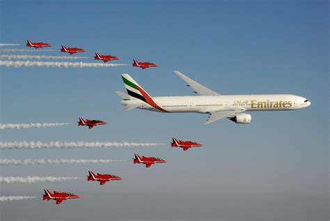 The Raf Red Arrows In Formation With An Emirates 777 300 During Day