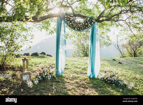 Sunset Wedding Ceremony Arch With Flower Decoration And Blue Cloth