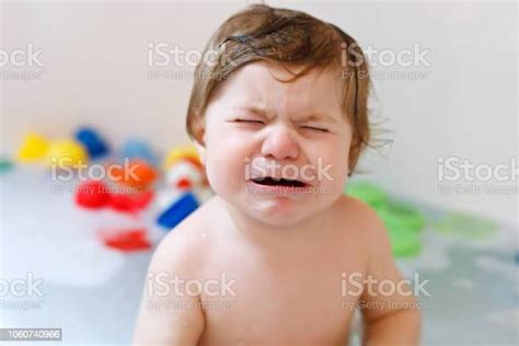 Cute Adorable Sad Baby Girl Taking Foamy Bath In Bathtub Crying Toddler