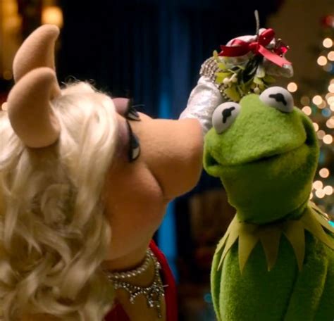 The Muppet And Miss Piggy Kissing In Front Of A Christmas Tree With Lights