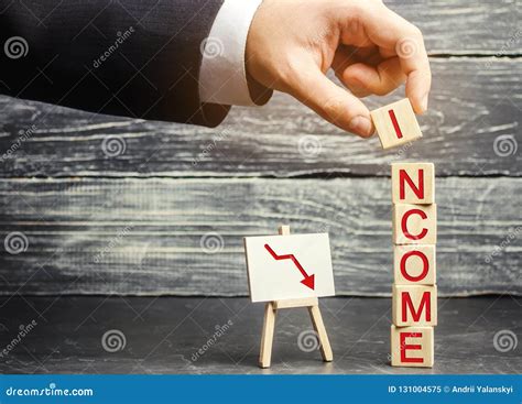 Businessman Puts A Cube With The Word Income And Down Arrow The