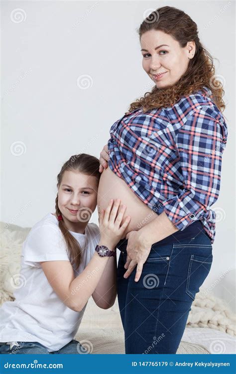 Pre Teen Daughter Listening Tummy Of Her Pregnant Mother Both Persons