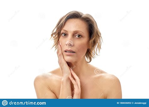 Beautiful Young Woman With A Short Haircut Is Touching Her Face Skin With A Slightly Open Mouth