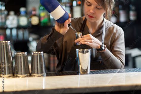 barmaid with shaker preparing cocktail at bar stock foto adobe stock