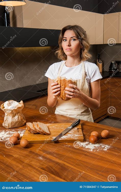 Pretty Young Housewife Looking Suspiciously At Bread In Her Hand Stock Image Image Of Cooking