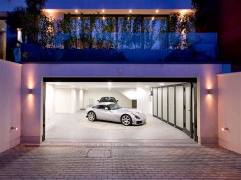 A Car Is Parked In The Middle Of A Driveway With Its Doors Open And Lights On