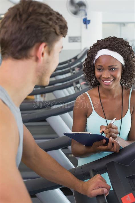 Fit Woman On Treadmill Talking To Personal Trainer Stock Image Image