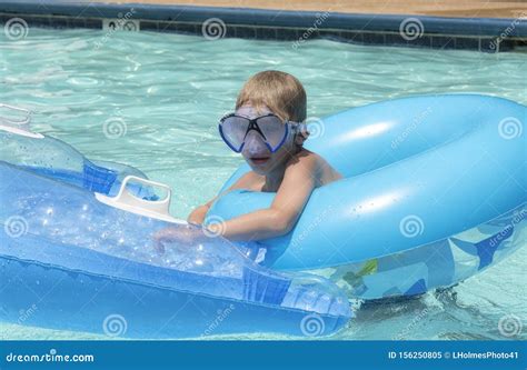 Young Blonde Caucasian Boy Using Two Floats In Swimming Pool Stock