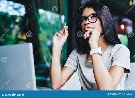 Brunette Pensive Young Woman Thinking while Doing Remote Job Via