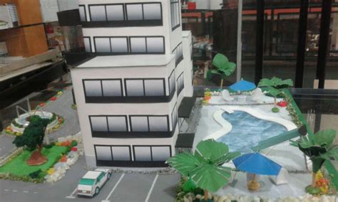 A Model Of A Building With Cars And Trees On The Street In Front Of It