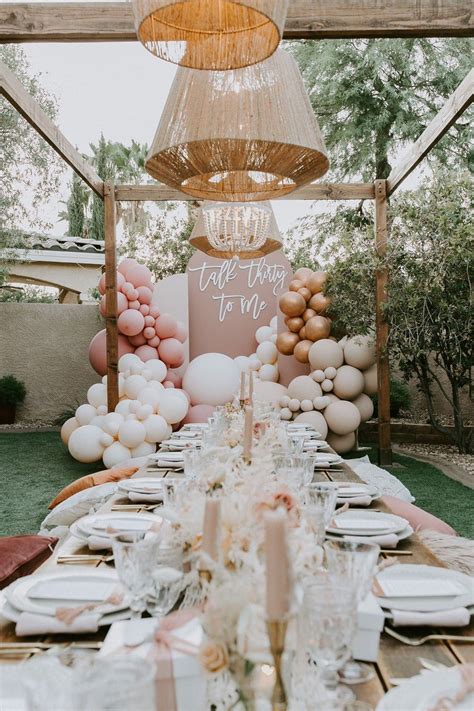 A Table Set Up With Balloons Plates And Napkins
