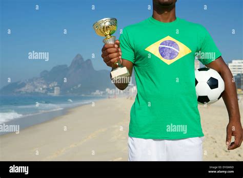 Champion Brazilian Soccer Player Holding Trophy And Football In