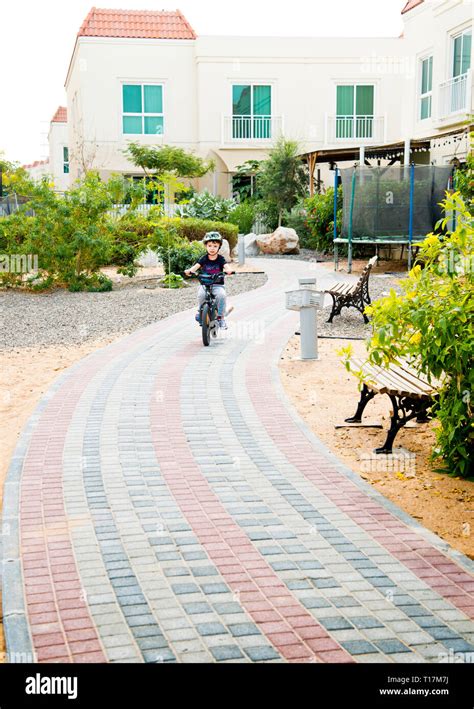 Young Boy Riding Bicycle Along A Paved Pathway Using Red Mono Blocks As