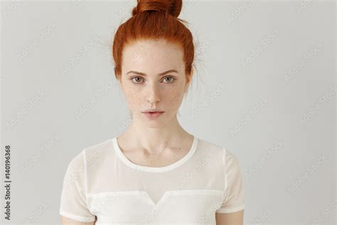 Indoor Portrait Of Attractive Good Looking Redhead Girl With Hair Bun And Freckles Having